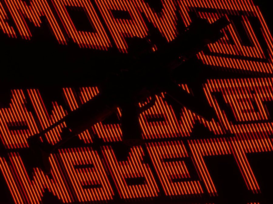 Silhouette eines Builds vor einem projizierten Umbrella-Armory-Schriftzug in Signalorange
